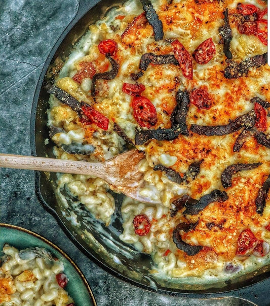 Bowl of creamy mac and cheese topped with Piri Piri biltong, a unique biltong recipe idea combining spice and protein