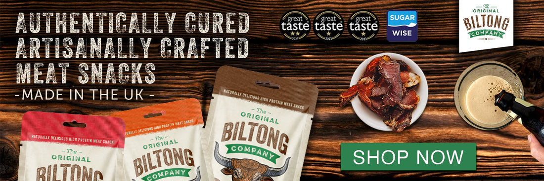 Authentically cured, artisanally crafted meat snacks, made in the UK. Great Taste and Sugar Wise badges beside bags of biltong and a bowl of sliced biltong on a wooden table.